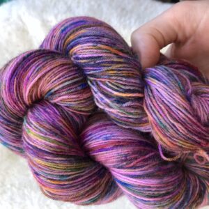 Un écheveau multicolore teint à la main et posé sur un fond de fausse fourrure blanche